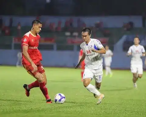 Cầu thủ Khánh Hòa áo trắng tranh bóng với cầu thủ CAND áo đỏ trên sân Nha Trang